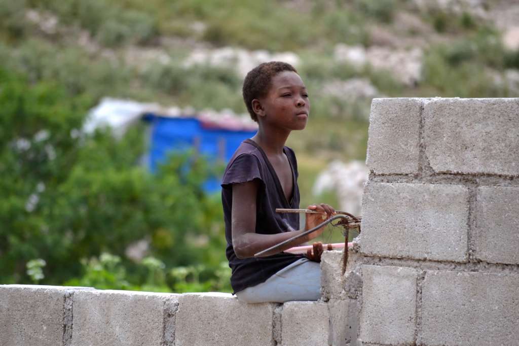Villager sitting on wall overlooking orphanage